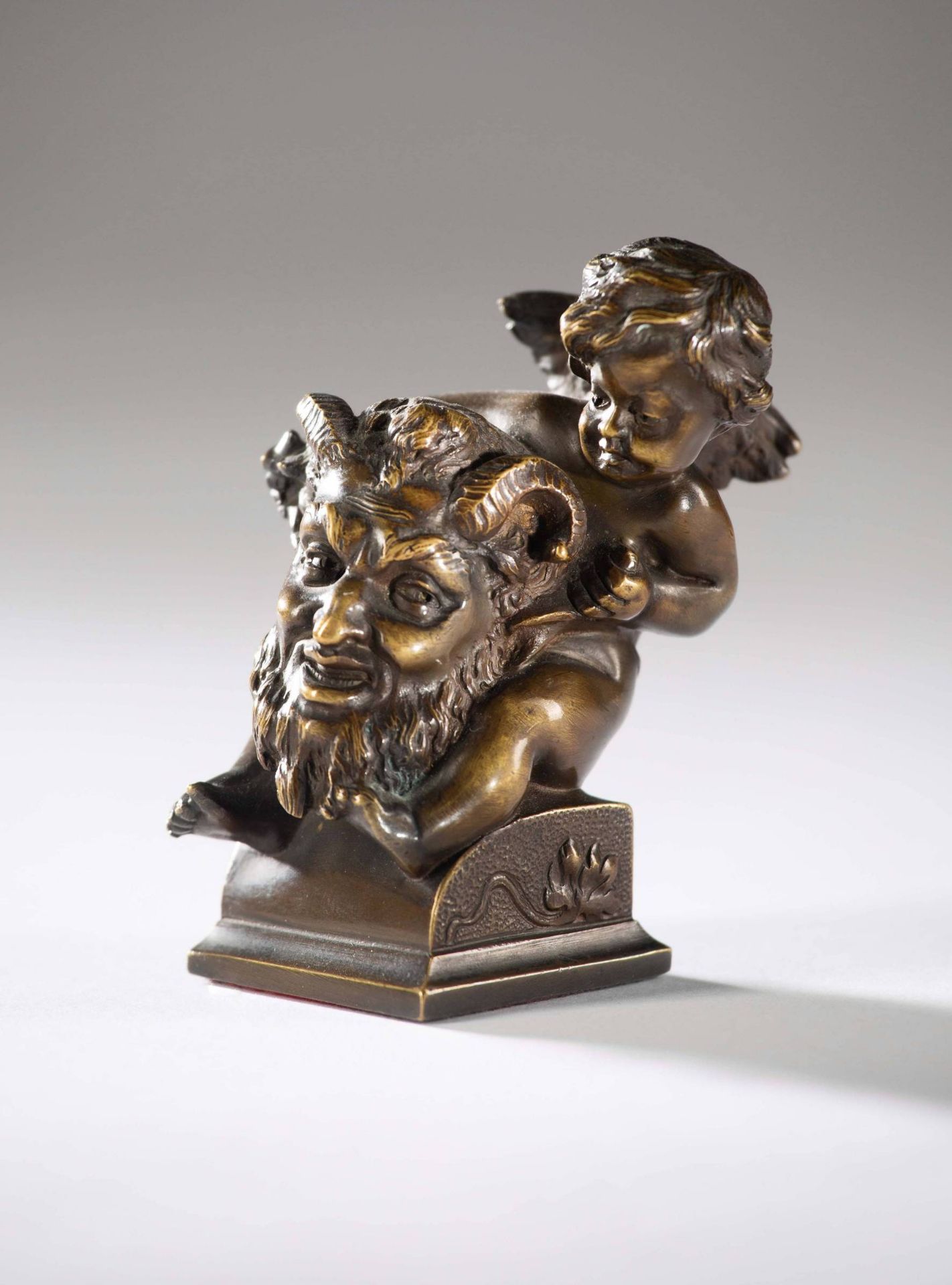 Kleine Tischbronze "Teufelskopf mit Putto".