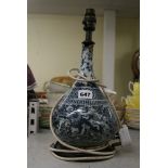 A black and white pottery bottle, probably Persian 19th century, painted with a lion and deer in a