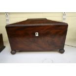 A substantial George IV mahogany sarcophagus tea chest, on gadrooned bun feet, retaining inner boxes