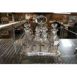 A large William IV silver cruet, with central handle and scroll feet, complete with six cut-glass