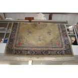 A Chinese wool carpet woven with flowers on a mustard field, blue outer border. FOR DETAILS OF