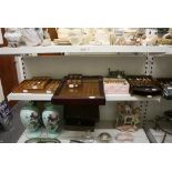 Two and a quarter shelves of collectables, comprising porcelain thimbles, collectors' spoons some