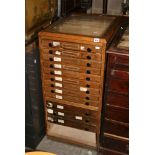 An early 20th century oak collectors' cabinet of 12 shallow drawers in two depths. FOR DETAILS OF