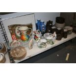 A shelf of miscellaneous pottery and porcelain including tea sets, square-section blue vases, a