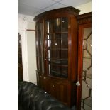 A handsome and large bow-fronted mahogany display cabinet, the pair of glazed doors enclosing