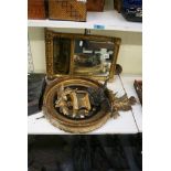 A small early 19th century giltwood circular mirror with convex plate and carved eagle cresting,