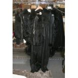 A black leather lady's Escada jacket with fox fur sleeves, a black velvet lady's Escada cape with