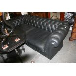 A handsome Chesterfield settee in deep buttoned black leather, seemingly unused (approx. 8 ft long),