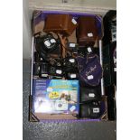A collection of various vintage cameras, including compact cameras, Nikon body, an Halina twin