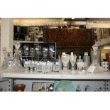 A shelf of crystal cut glass ship's decanters and drinking vessels, including a set of Italian