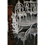 A circular aluminium garden table of pierced decoration and four matching chairs each with oval