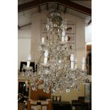 A pair of gilt-metal scrolling 12-light chandeliers with buttons and prism drops, 33 in drop FOR