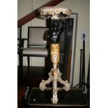 A highly decorative occasional table in cream, gold and black on a blackamoor-style support and