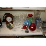 Half a shelf with a selection of various glass drinking vessels, decorative glass vases, a Murano