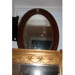 A large oval wall mirror with bevel plate and moulded frame. FOR DETAILS OF ONLINE BIDDING ON THIS