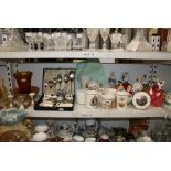 Two shelves of commemorative and domestic tableware and Royal Doulton figures, coffee cans,