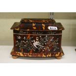 A pretty early Victorian tortoiseshell tea caddy, bow-fronted and with pagoda top, inlaid with birds