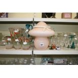 A shelf of glass ware including a Stuart crystal tumbler, four black stemmed cocktail glasses,