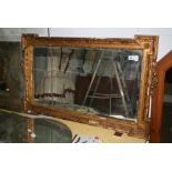 A Victorian overmantel, the three rectangular mirror plates in a gilt, moulded and carved frame. FOR