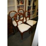 A set of 12 Victorian-style balloon back mahogany dining chairs each with a white fabric seat and