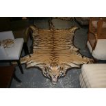 An early 20th century tiger skin rug with a fully mounted head, glass eyes, by Rowland Ward Ltd, the