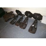 A set of four iron supports for stools or low tables, each cast as an exotic female on separate base