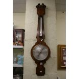 A Georgian-style wheel barometer and thermometer [wall between shelves] FOR DETAILS OF ONLINE