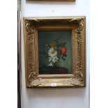 A late 19th/early 20th century oils on panel still life of flowers in a glass vase (32 x 24 cm),