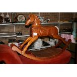 A carved rocking horse on wooden rockers with plastic eyes and a grey tail. FOR DETAILS OF ONLINE