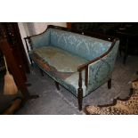 An Edwardian settee in Regency style, the reeded mahogany frame on six tapering legs. FOR DETAILS OF