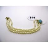 A three-row cultured pearl bracelet with turquoise clasp. FOR DETAILS OF ONLINE BIDDING ON THIS