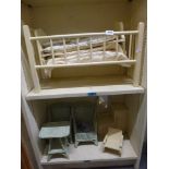 A collection of dolls furniture including a cot, wicker style table and chairs and wardrobe with