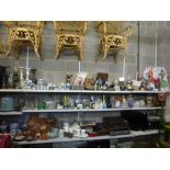 Three and a half shelves of mixed items including oil lamps, pricket candlesticks, storm lamp,