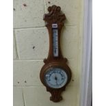 A carved oak wall barometer, aneroid, with thermometer, by Aitchison, London, circa 1900 [by