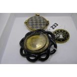 A large Whitby jet and yellow metal brooch, a large 9 ct and plaited hair-work brooch, and a