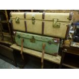 Two cabin trunks one with leather corners, covered in green canvas, the other cream with wooden