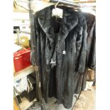 A glamorous lady's full-length dark brown/black mink fur coat with shawl collar, concealed front