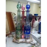 A matched harlequin set of three mid-19th century decanters, in blue, cranberry, and green overlay