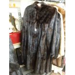 A stylish lady's full-length dark brown mink fur coat with swing back, gathered cuffs, buttoned