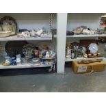 Two shelves of mixed items including three wooden cased wall clocks, two barometers, glass sangria
