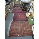 Four Eastern rugs mainly in tones of red and blue [floor by collectors' shelves] FOR DETAILS OF