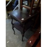 A Victorian ebonized games table with a hinged revolving top raised on cabriole supports with an