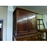 A 19th century mahogany small cupboard the pair of panel doors enclosing a shelf raised on a plinth.