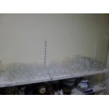 A shelf and glass of mainly drinking glasses including a set of six cut glass champagne flutes,