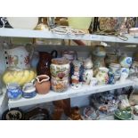 Two shelves of 19th century and later jugs including faience, Wedgwood, Portmeirion, lustre ware,