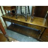A reproduction oak serving table of three frieze drawers above a pan shelf on turned legs (