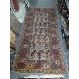 An old Eastern rug of unusual design, woven with stylised hook motifs on a white field, polychrome