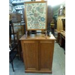 A mahogany cupboard enclosed by a pair of panel doors, a glazed embroidered screen styled as a
