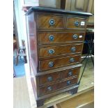 A reproduction miniature chest of four short and four long drawers on bracket feet. FOR DETAILS OF