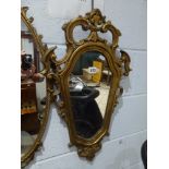 A 19th century mirror with pierced shell frame plus a more modern shaped mirror with scrolling
